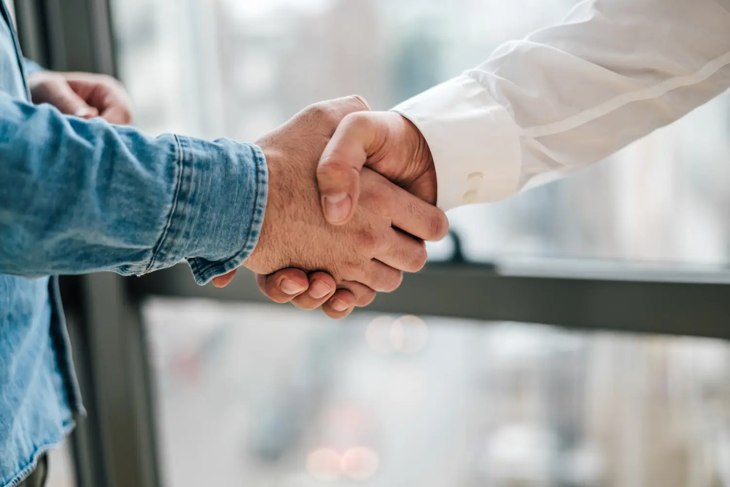 Recruitly Personal Service, 2 Personen beim Händeschütteln in Großaufnahme